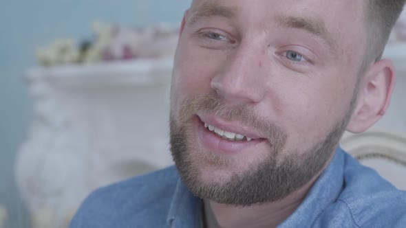 Close Up Face Smiling Positive Smiling Bearded Man in Blue Shirt Sitting in the Armchair