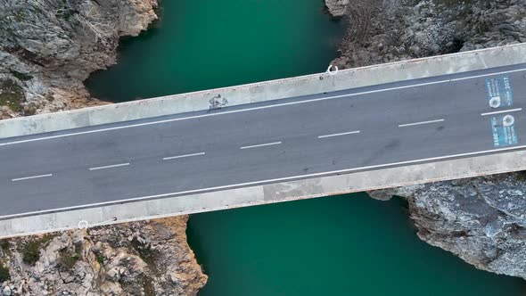 A car passes through a bridge over a river aerial view 4 K