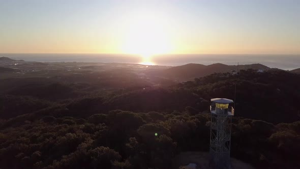 View of gorgeous white sun, rays, flare and beam on ocean horizon at sunset and flyby lookout tower