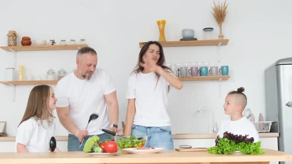 The Family Prepares a Healthy Dinner and Has Fun in the Kitchen Dancing to Music