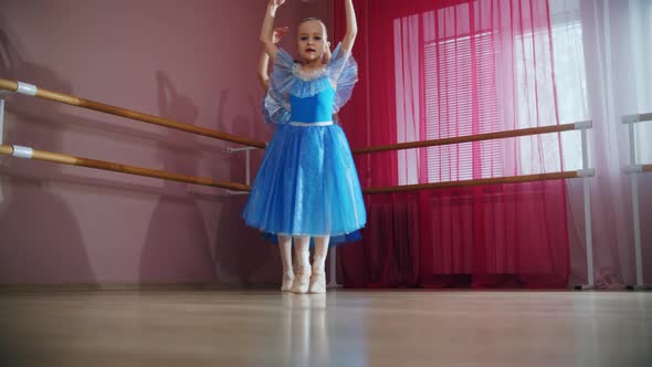 Four Ballerina Girls in Blue Dresses Walk in a Row and Go Around on Their Tip Toes