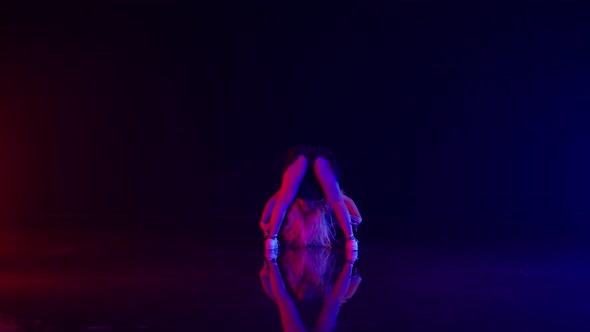 Sexy Young Woman in Policeman Hat Dances in Colorful Stage Lights in Studio