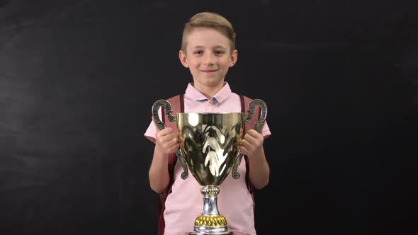 Happy Schoolboy Holding Bowl Award