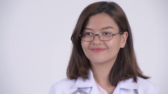 Face of Happy Young Beautiful Asian Woman Doctor Thinking