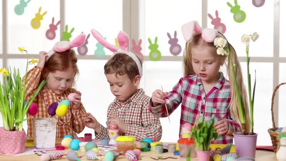 Happy Children Wearing Bunny Ears Painting Eggs on Easter Day