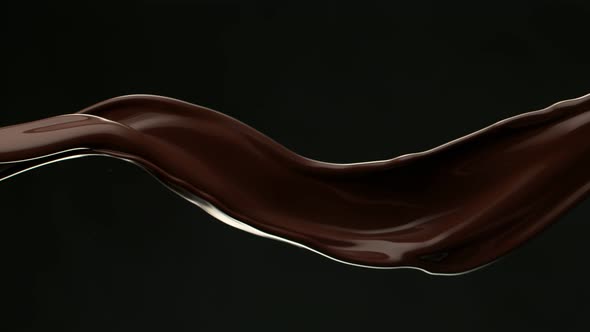 Super Slow Motion Shot of Waving Chocolate Splash Isolated on Black Background at 1000 Fps