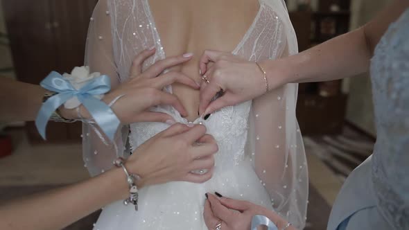 Bridesmaid Helps Zip Up Wedding Dress for Beautifull Bride on Marriage Day