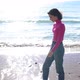 Dressed Young Woman Along the Coastline and Smiling - VideoHive Item for Sale