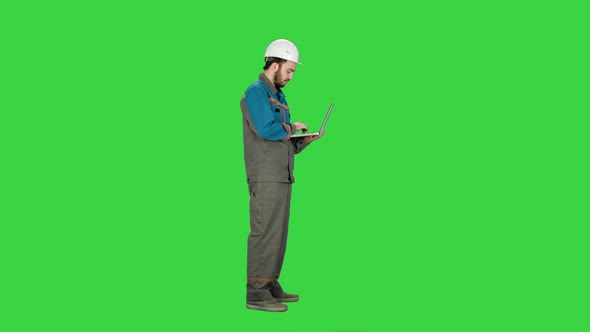 Attractive Engineer Using Laptop on a Green Screen, Chroma Key.