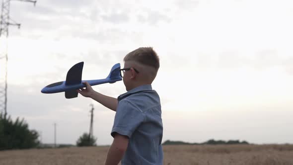 Happy guy with a toy airplane on a wheat field in the sunset light.