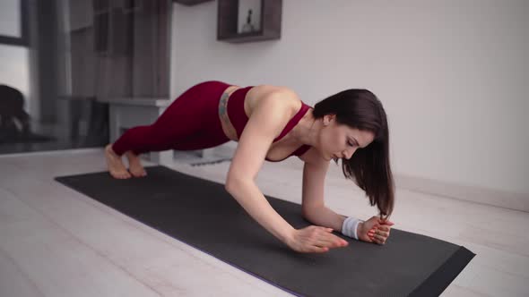 Fit and Tone Up Woman Doing Doing Plank Changing Elbows at Home