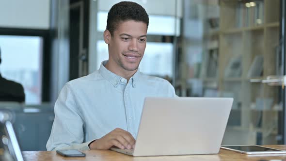 Young African Man Doing Video Chat at Work