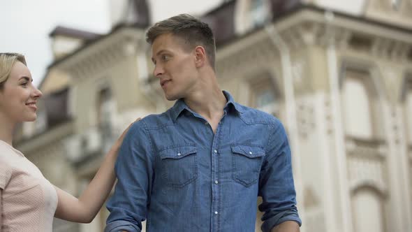 Anxious guy waiting for his beloved girlfriend, couple hugging and kissing, love