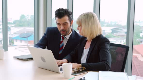 Two Business People Talk Project Strategy at Office