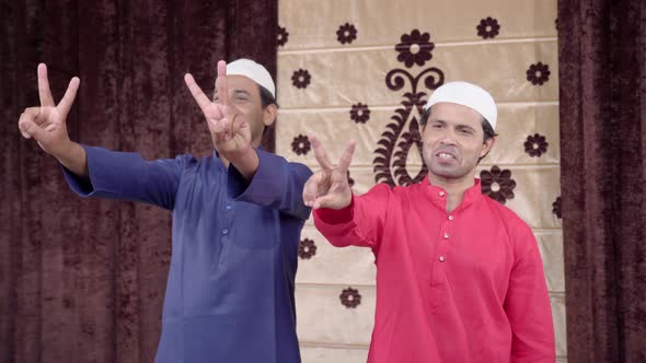 Two Muslim men showing victory sign