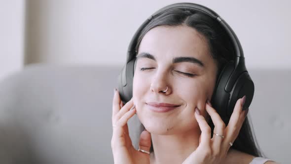 Young Woman in Headphones Listening to Music at Home