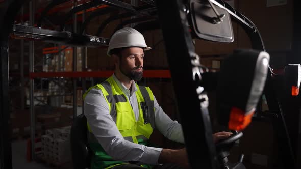 Confident Warehouse Worker Driving Forklift Truck