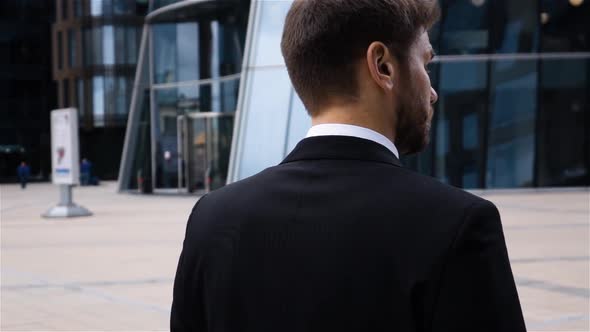 Back View Businessman Turning His Head with Suspicion and Looking at Camera