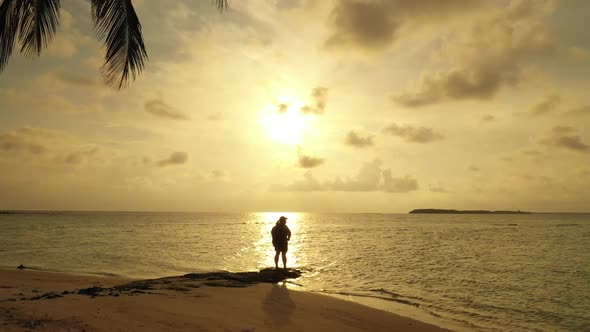 Lady sunbathing on tropical lagoon beach break by blue ocean and white sand background of the Maldiv