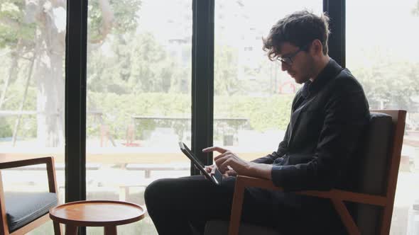 Businessman in suit wearing glasses use tablet to check email online and learning and reading news