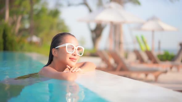 Young asian woman enjoy around outdoor swimming pool for leisure