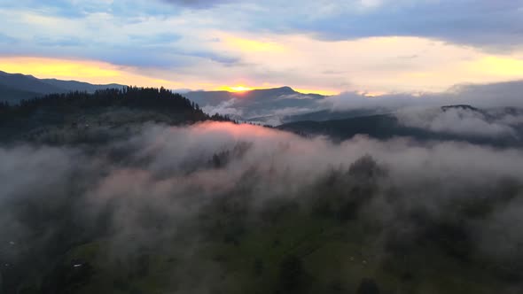 Mist covering and surrounding hilltops on a early morning during sunrise in wild landscape