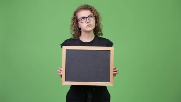 Young Happy Beautiful Nerd Woman Thinking While Holding Blackboard