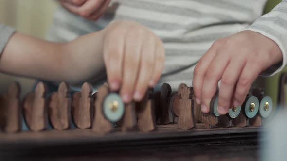 Close Up Children's Hands That Play an Old Board Game