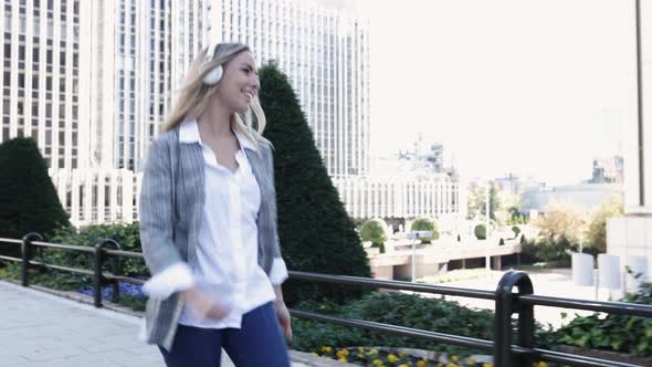 Young Businesswoman Listening to Music with Headphones and Dancing in Financial