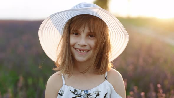 Close up Portrait of Young Happy Little Girl With a Hat on Her Head in Lavender Fields