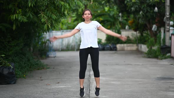 4K footage of A white T-shirt woman doing exercise with jumping and slapping.