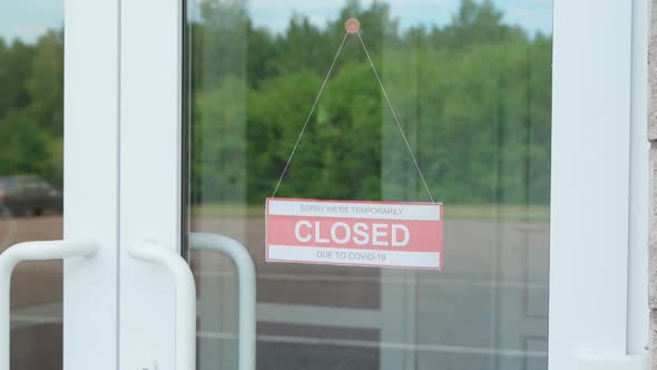 The Man Changes the CLOSED Sign for the OPEN Sign