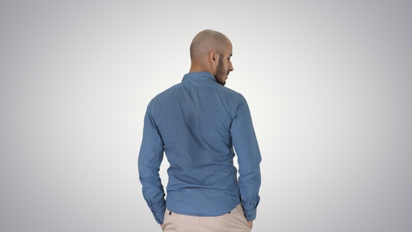 Arab in casual looking around with hands in pockets on