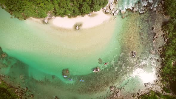 Aerial view of people doing rafting surrounded by rocks at Soca river, Slovenia.