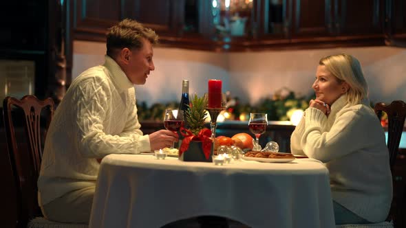 Side View Happy Loving Adult Couple Sitting at Dinner Table Talking Smiling