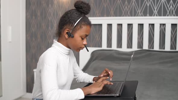 Homeschooling Online a African Teen Girl Uses a Laptop to Study on Selfisolation at Home Studying