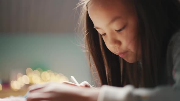 Dreaming Asian girl writing something in notepad