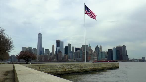Skyline view of Manhattan, New York, as seen from Liberty Island. American flag.