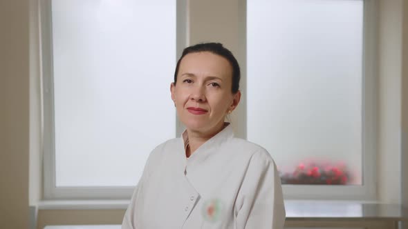 Portrait of Smiling Female Doctor Satisfied with Her Job in a Corridor of a