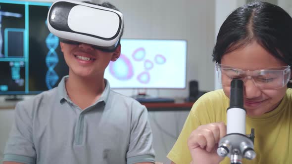 Boy And Girl Learning Science Experiment In Laboratory. Study With VR Headset And A Microscope