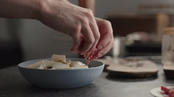 Slow Motion Add Cured Sausage to Fusilli Pasta in Blue Bowl