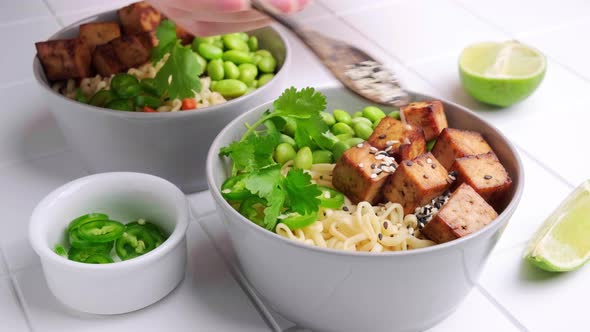 Vegan noodles ramen soup with marinated tofu, edamame beans and hot peppers.