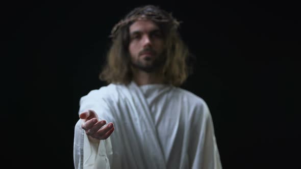 Son of God in Crown of Thorns Stretching Out Hand on Dark Background, Mercy