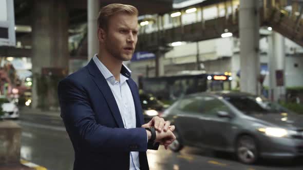 Businessman checking the time, Bangkok, Thailand