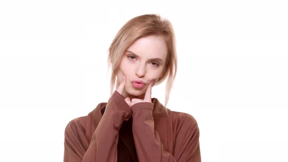 Cute Caucasian Young Teenager Girl Making Duck Face and Other Grimaces Looking at Camera on White