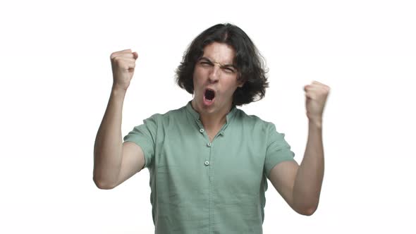 Video of Handsome Hispanic Man in Green Shirt Triumphing Shouting for Joy and Making Fist Pump