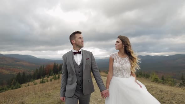 Lovely Young Newlyweds Bride Groom Walking on Mountain Slope Making a Kiss Wedding Couple Family