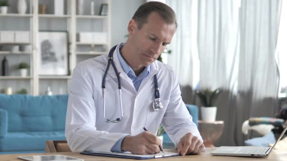 Senior Doctor Writing Medical Documents Prescription for Patient