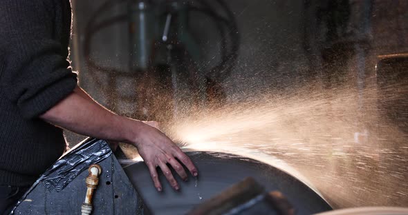 Bladesmith wet grinding a blade