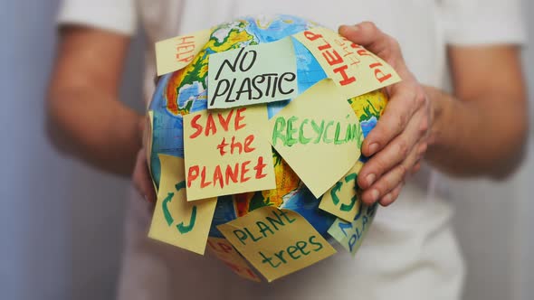 Man Hands Hold Earth Globe with Stickers